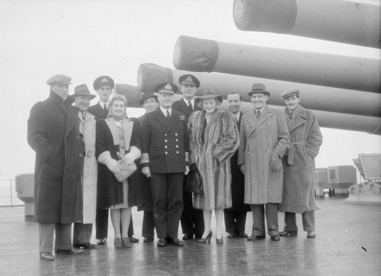 Британские актеры театра и кино с офицерами Королевского ВМФ Великобритании на квартердеке линкора «Дюк оф Йорк». Апрель 1944 г. 