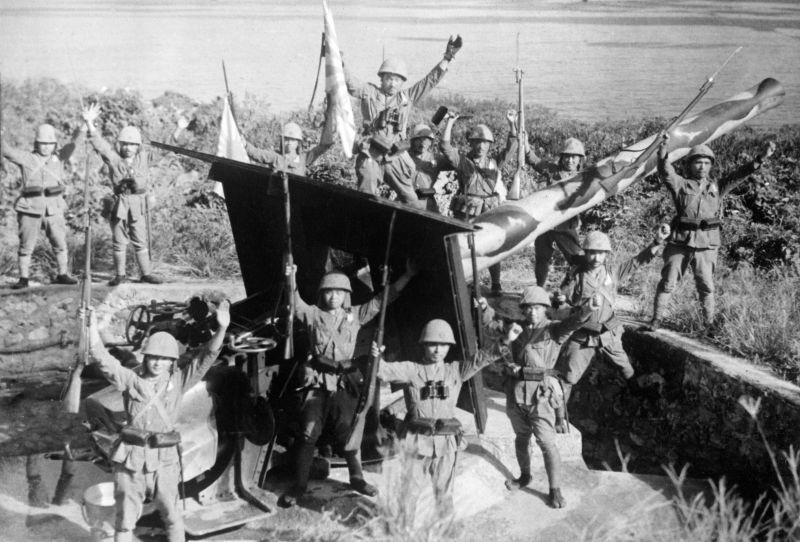Японские солдаты ликуют у захваченного британского 150-мм берегового орудия на острове Рождества. 31 марта 1942 г. 