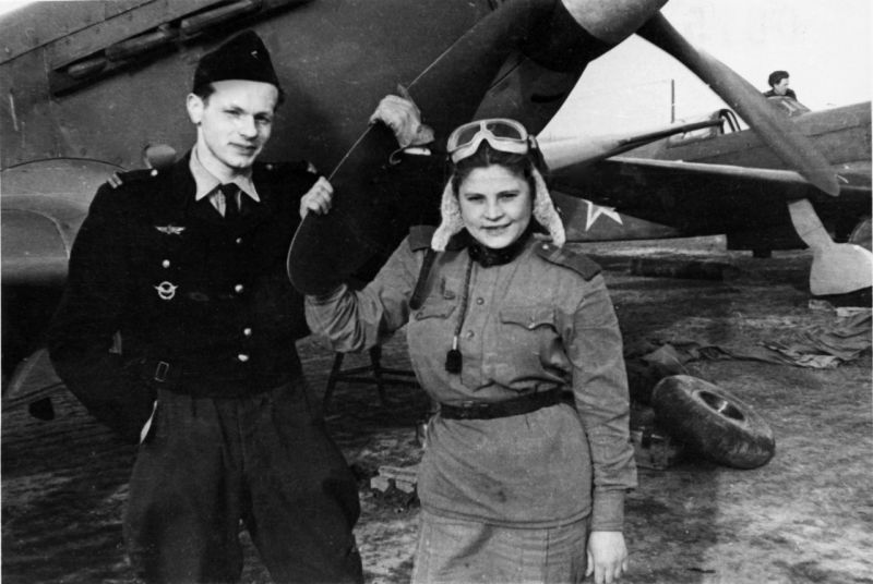 Летчик-истребитель авиаполка «Нормандия» Ролан де ла Пуап с советской девушкой-авиатехником на аэродроме. 1943 г. 