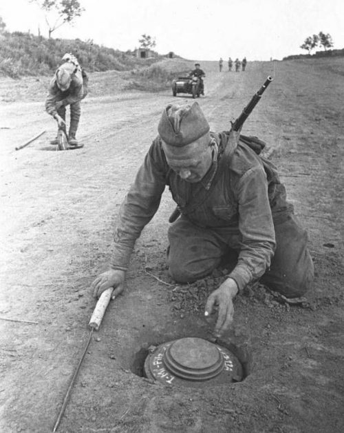 Извлечение немецкой противотанковой мины, обнаруженной с помощью самодельного щупа.