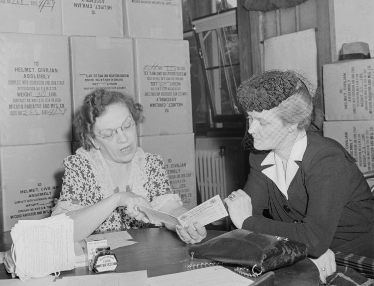Американской женщине выдают карточку на сахар в Вашингтоне, май 1942 года.