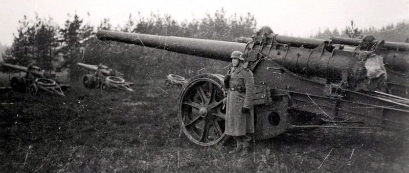 Немецкий часовой охраняет захваченные французские 145-мм пушки. 1940 г.