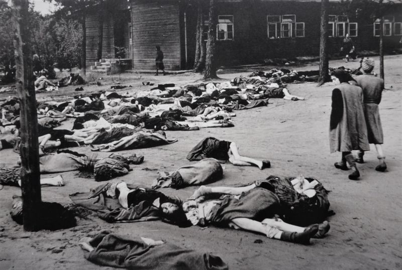 Тела умерших узниц концлагеря Берген-Бельзен на фоне лагерного барака. Апрель 1945 г. 