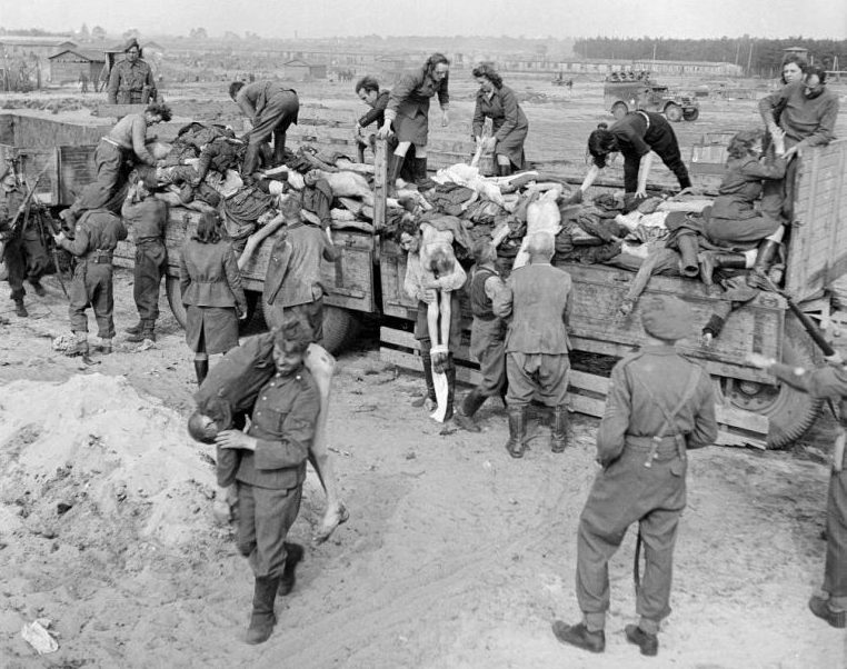 Бывшие охранники и охранницы Берген-Бельзена выгружают тела узников под конвоем британских солдат. Апрель 1945 г. 