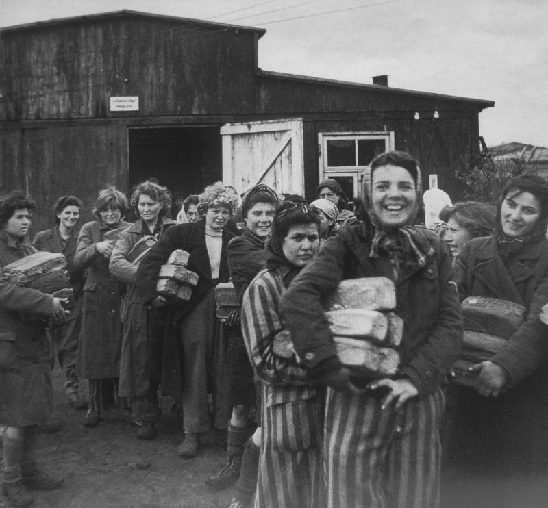 Освобожденные узницы концлагеря Берген-Бельзен, получившие хлеб. Апрель 1945 г. 