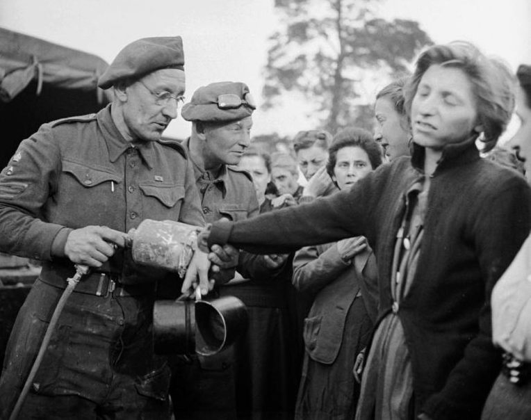 Британский сержант-медик проводит дезинсекцию бывших узниц концлагеря Берген-Бельзен. Апрель 1945 г.