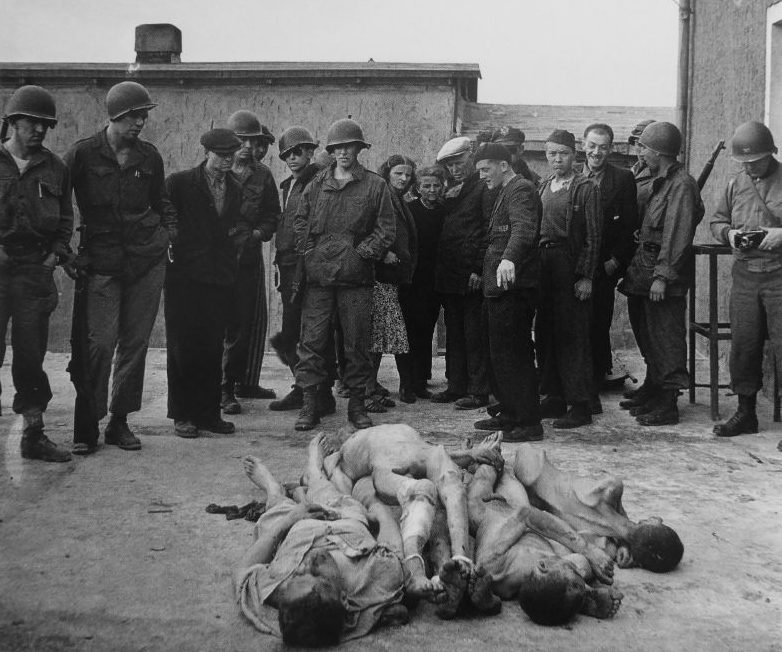 Освобожденные узники и американские солдаты возле тел, погибших в концлагере Бухенвальд. Апрель 1945 г. 