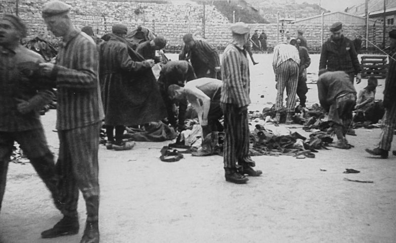 Советские военнопленные, доставленные в концлагерь Гузен, снимают форму.1942 г. 