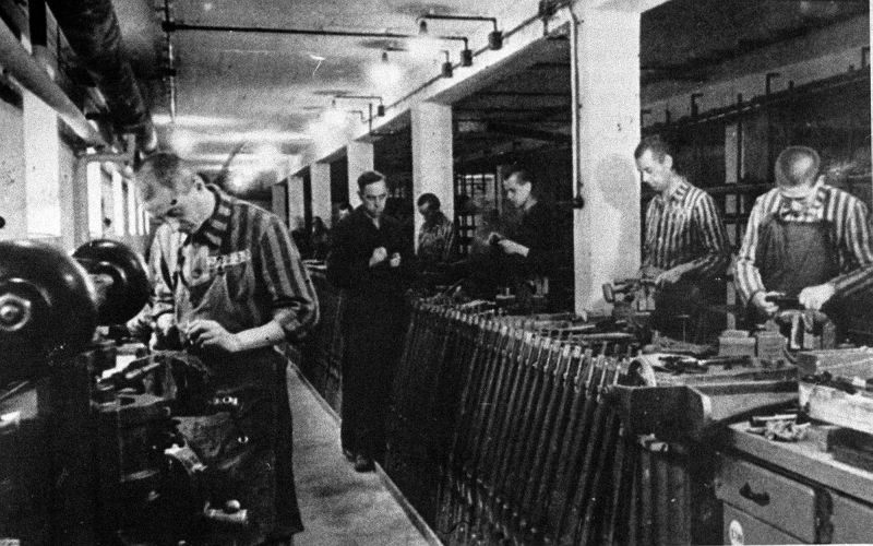 Узники концлагеря Дахау работают в цехе оружейного завода. 1942 г. 
