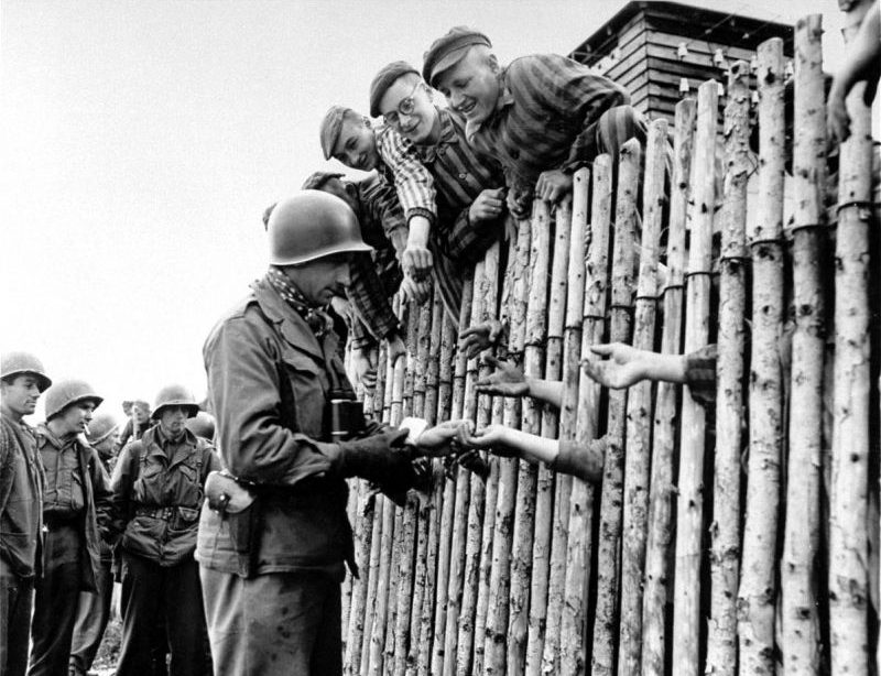Американец угощает сигаретами узников освобожденного концлагеря Аллах. Апрель 1945 г. 