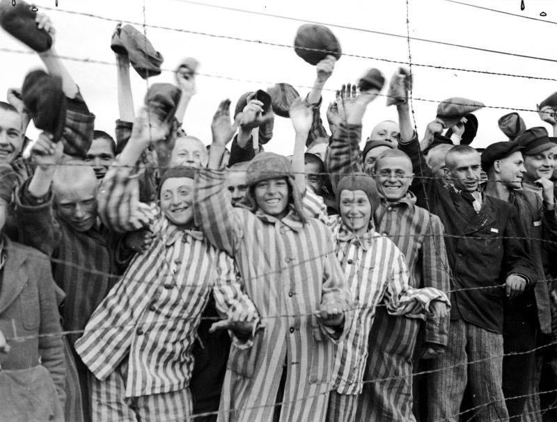 Заключенные концлагеря Дахау приветствуют американцев при освобождении лагеря. Апрель 1945 г. 
