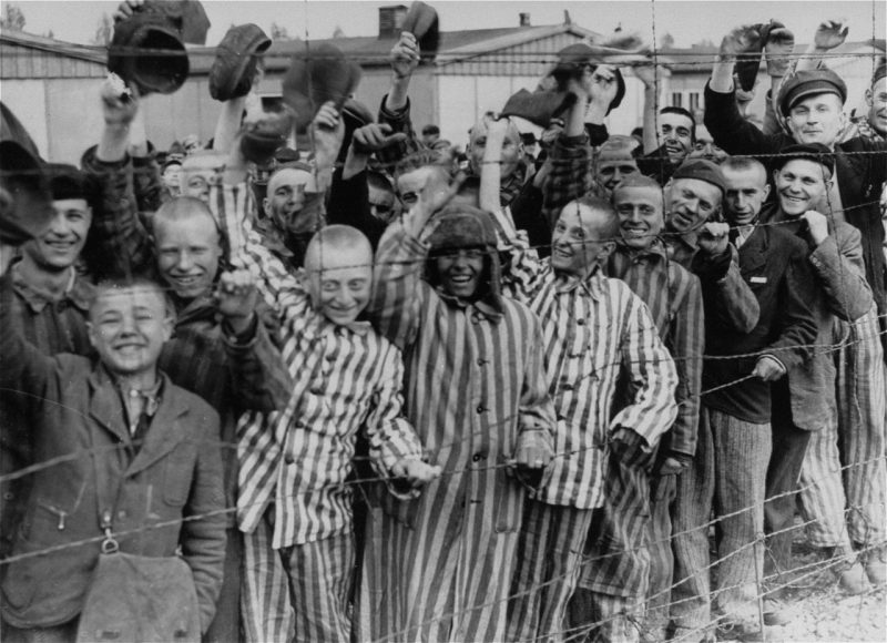 Заключенные концлагеря Дахау приветствуют американцев при освобождении лагеря. Апрель 1945 г.