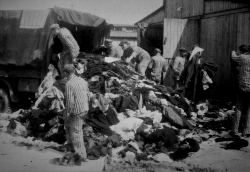 Узники концлагеря Освенцим у выгруженной из грузовика одежды евреев из Венгрии. Май 1944 г. 