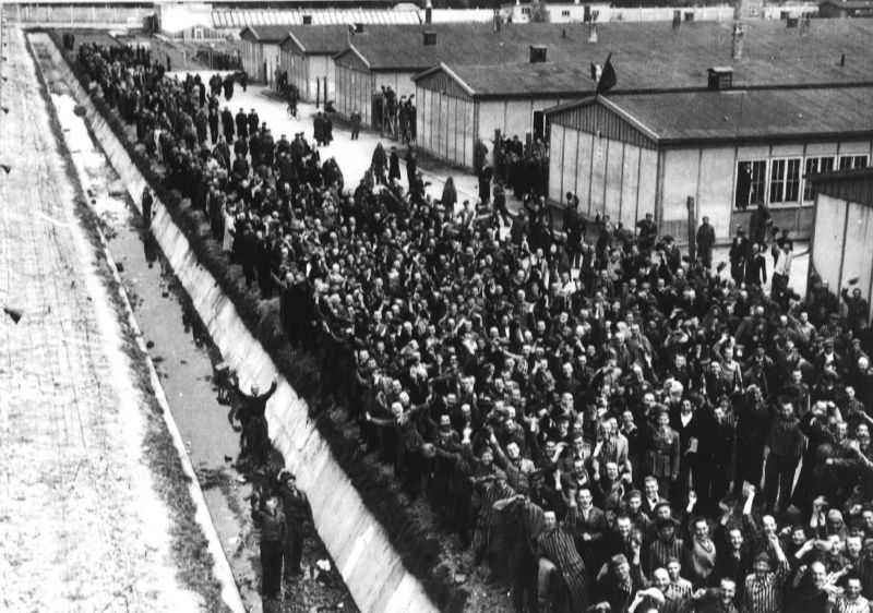 Освобожденные узники концлагеря Дахау возле лагерных бараков. Май 1945 г. 