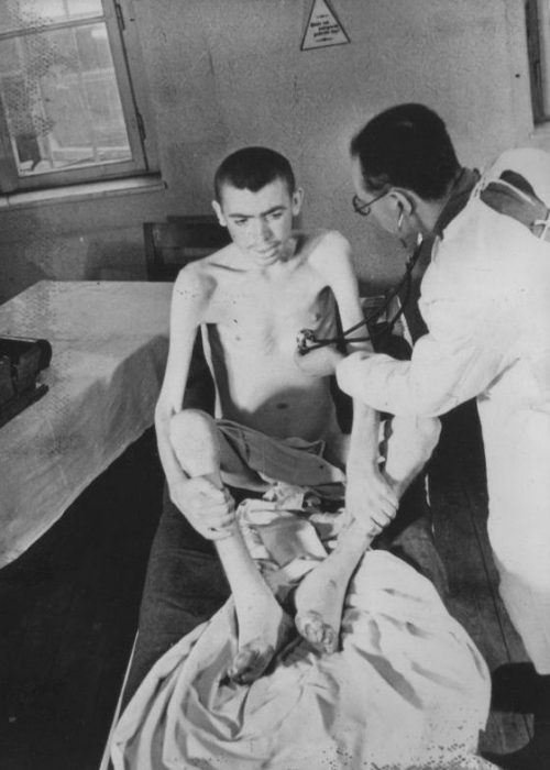 Советский врач осматривает освобожденного узника концлагеря Освенцим. 1945 г.