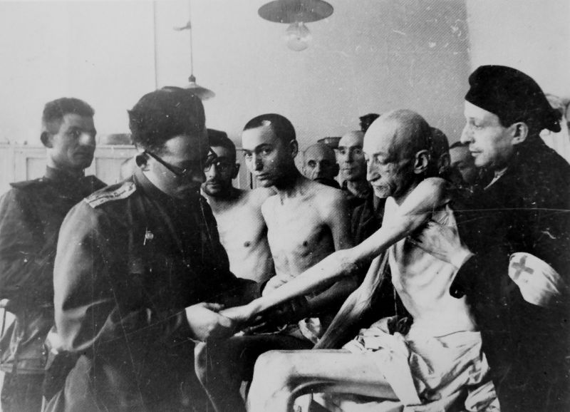 Советский медик осматривает освобожденных узников концлагеря Освенцим. Январь 1945 г. 
