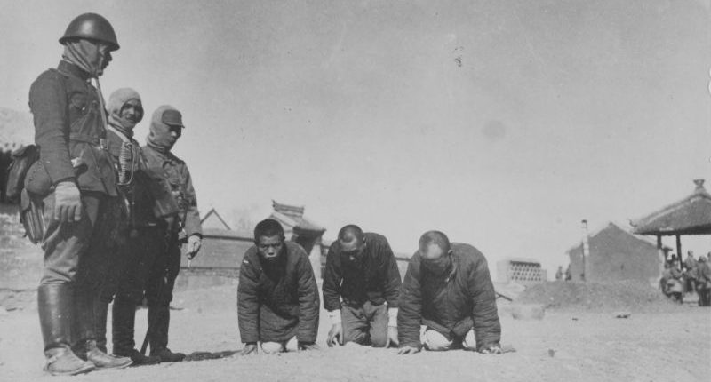Китайские пленные стоят на коленях перед японскими солдатами. 1940 г. 