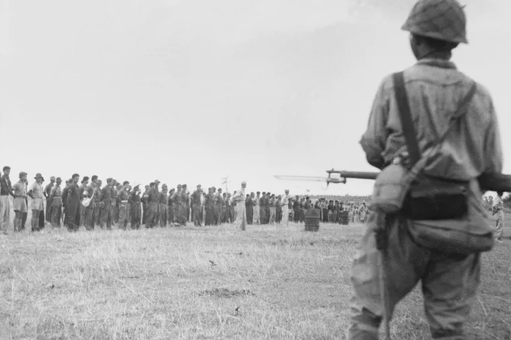 Пленные американцы под конвоем японцев идут в 97-километровый путь в так называемый «Батаанский марш смерти». Апрель 1942 г. 