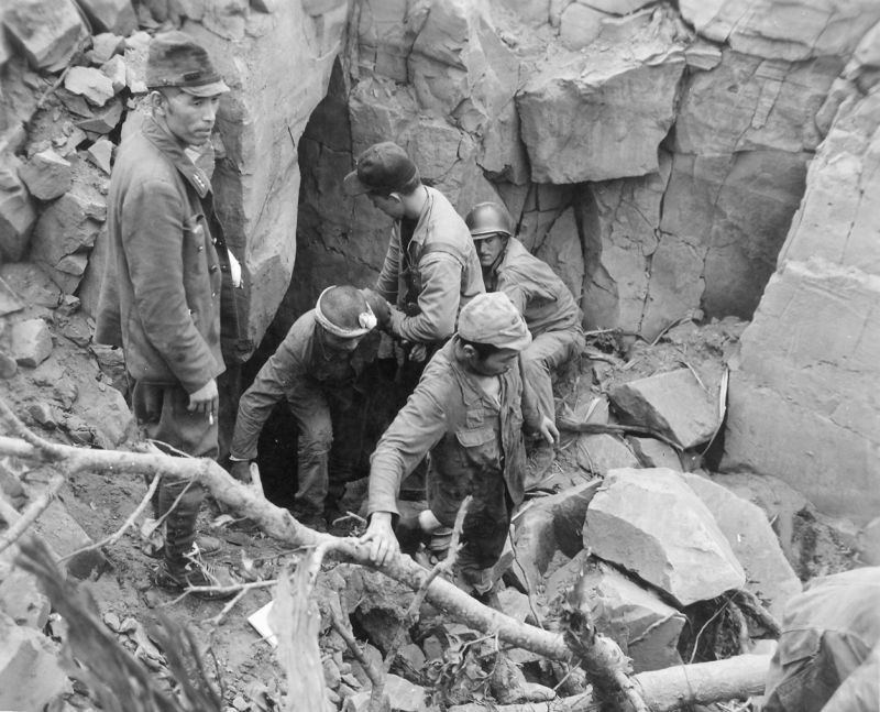 Японские военнопленные выбираются из пещеры на Иводзиме. Февраль 1945 г. 