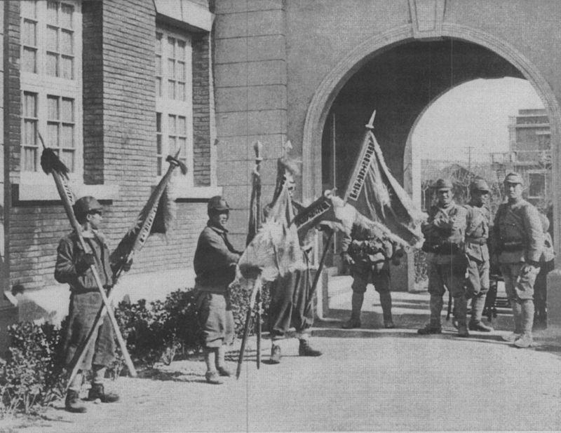 Японские солдаты позируют с захваченными китайскими флагами в Нанкине. Декабрь 1937 г. 