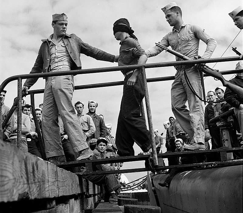 Морские пехотинцы выгружают японских военнопленных с подводной лодки, вернувшейся с боевого патрулирования. Май 1945 г.