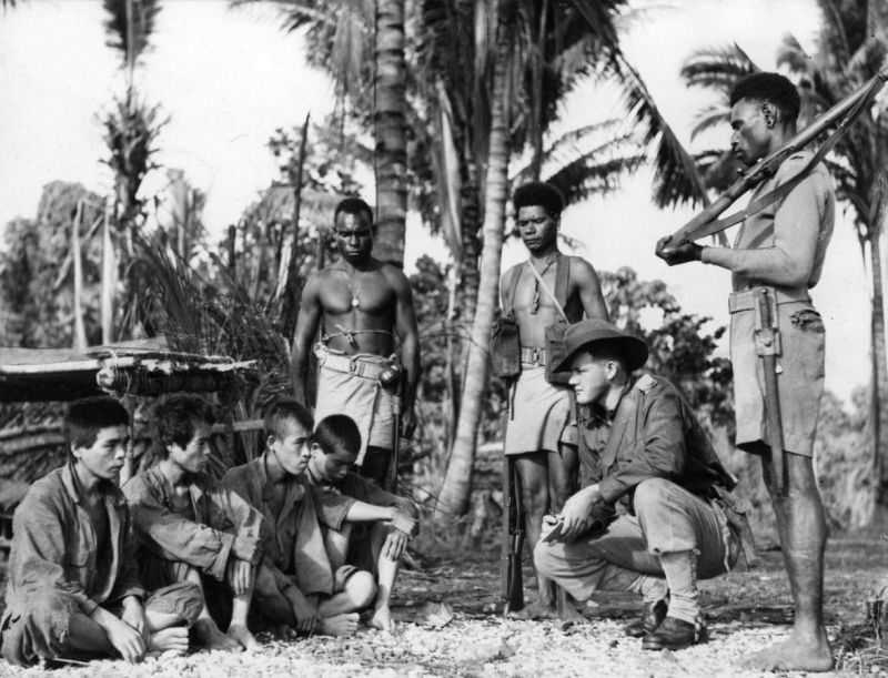 Австралийский военнослужащий допрашивает пленных японских солдат. Новая Гвинея, июль 1945 г. 