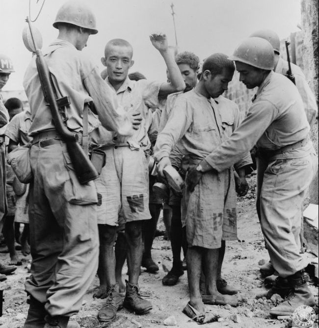 Американские солдаты обыскивают японских пленных. Июль 1945 г.