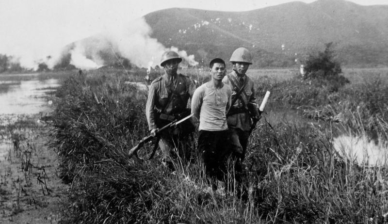 Офицер и солдат японской армии конвоируют китайского партизана в провинции Гуандун. 1941 г.