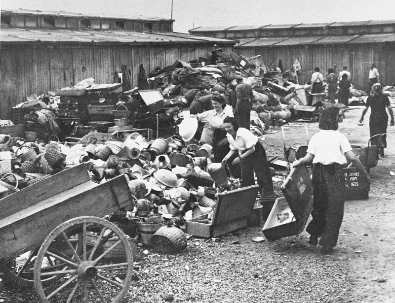 Заключенные выгружают конфискованное имущество из вагона евреев из Подкарпатской Руси на склад в концлагере Аушвиц-Биркенау. Апрель 1944 г.
