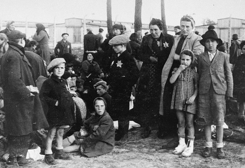 Еврейские мужчины, женщины и дети ждут смерти в роще возле газовой камеры №1 концлагеря Освенцим-Биркенау. Май 1944 г.