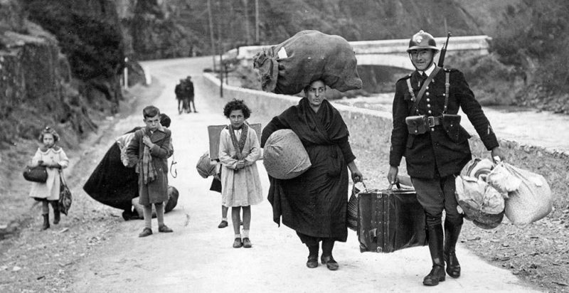 Французский пограничник помогает семье испанских беженцев при переходе через испано-французскую границу. 1937 г.