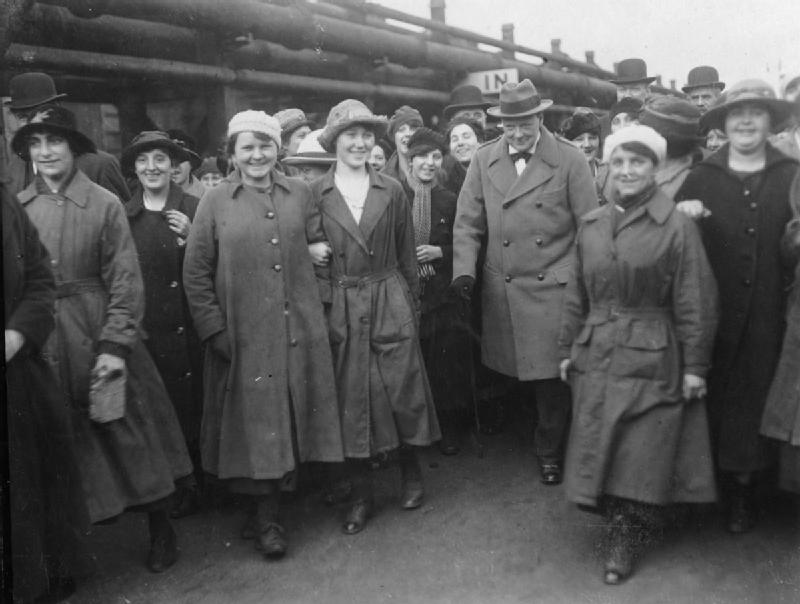 Министра вооружений Уинстона Черчилля сопровождают работницы во двор Джорджтаунского заправочного завода недалеко от Глазго. 1918 г.