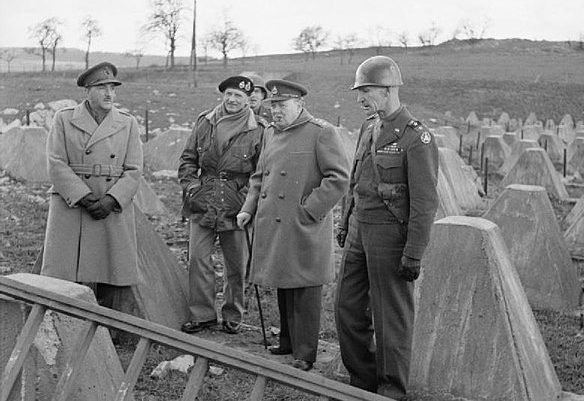 Начальник Генерального штаба фельдмаршал А. Брук с премьер-министром В. Черчиллем, фельдмаршалом Б. Монтгомери и командующим 9-й американской армией В. Симпсоном у фортификационных сооружений линии Зигфрида. 1945 г.