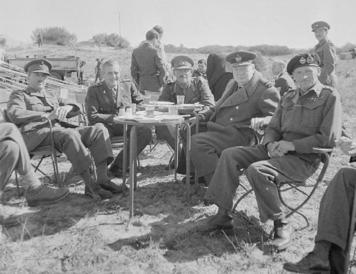 Обед на свежем воздухе премьер-министра Уинстона Черчилля вместе с генералом Бернардом Монтгомери и другими офицерами Восьмой армии во время визита Черчилля в Триполи. 1943 г. 