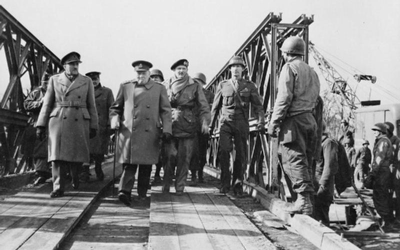 Фельдмаршал сэр Алан Брук, Уинстон Черчилль, фельдмаршал сэр Бернард Монтгомери и генерал-лейтенант Уильям Симпсон на мосту Бейли через Рейн. 1945 г.
