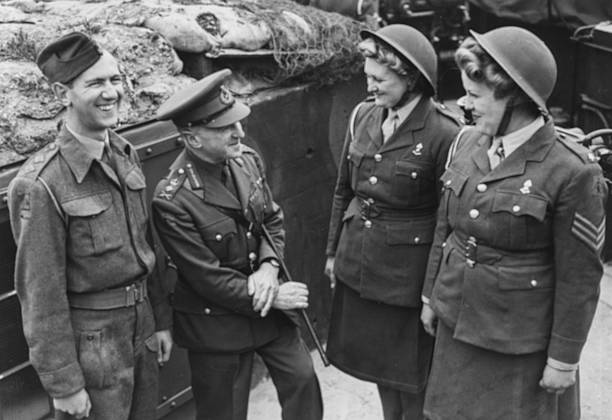 Генерал Фредерик Пайл поздравляет корректировщиков ОВД рядового Рене Болланда и сержанта Хейзел Тестер после сбитого самолета. 1943 г. 