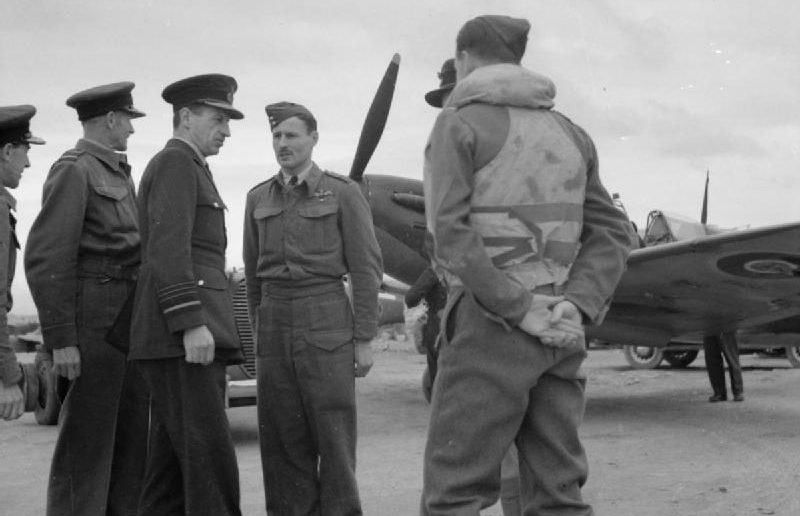Чарльз Портал с пилотами 126-й эскадрильи Королевских ВВС возле их кабины экипажа в Луке во время своего визита на Мальту. 1941 г. 