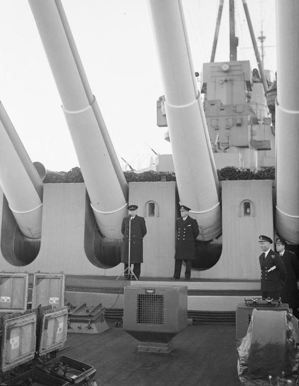 Первый лорд с главнокомандующим флотом метрополии адмиралом сэром Джоном Тови, обращаются к корабельной роте флагмана флота HMS «KING GEORGE V» под кормовыми 14-дюймовыми орудиями. 1943 г.