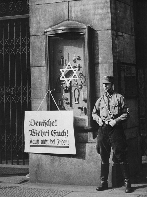Бойкот евреев. Плакат с надписью «Немцы, защищайтесь, не покупайте у евреев» в еврейском магазине. 1933 г.