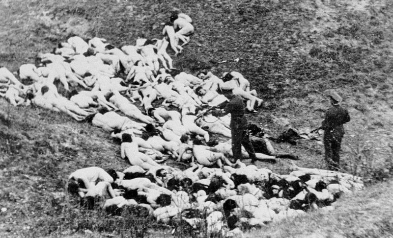 Полицейский расстреливает оставшихся в живых еврейских женщин после массовой казни евреев из гетто Мизоч. 1942 г.