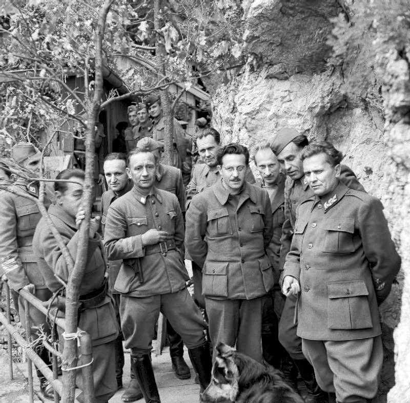 Маршал Тито стоит со своим кабинетом министров и Верховным штабом в своей горной штаб-квартире в Югославии.