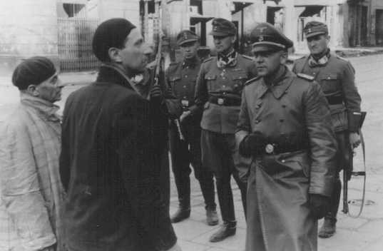 Лидер СС и полиции Юрген Штруп допрашивает двух евреев, арестованных в Варшавском гетто. Май 1943 г.
