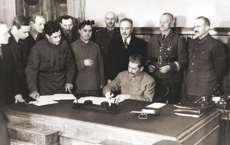 Иосиф Сталин подписывает совместное советско-польское заявление в присутствии премьер-министра Польши генерала Владислава Сикорского, генерала Владислава Андерса, Станислава Кота и других. 1941 г. 