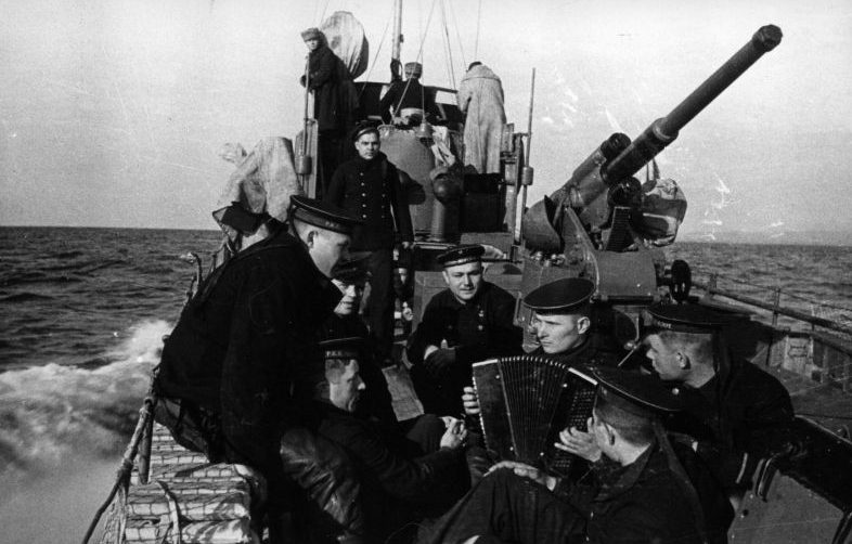 Моряки малого охотника СКА-092 слушают гармониста во время похода. 1942 г.