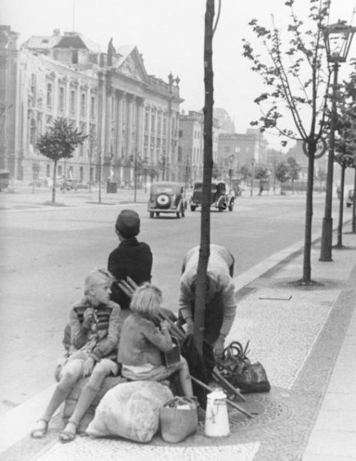 Семья переселенцев со своим имуществом отдыхает на углу Унтер-ден-Линден и Фридрихштрассе. Берлин, 1946 г.