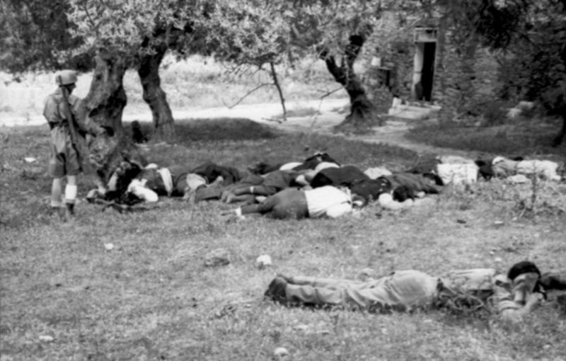Парашютист у тел расстрелянных жителей деревни Кондомари на Крите. Июнь 1941 г. 
