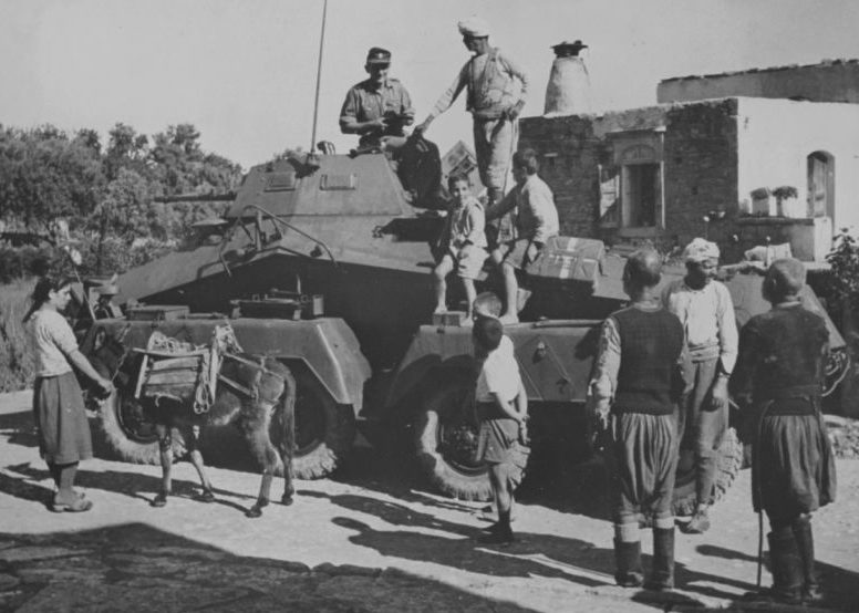 Немецкий солдат и местные жители у бронеавтомобиля Sd.Kfz.231 на Крите. Июнь 1941 г.