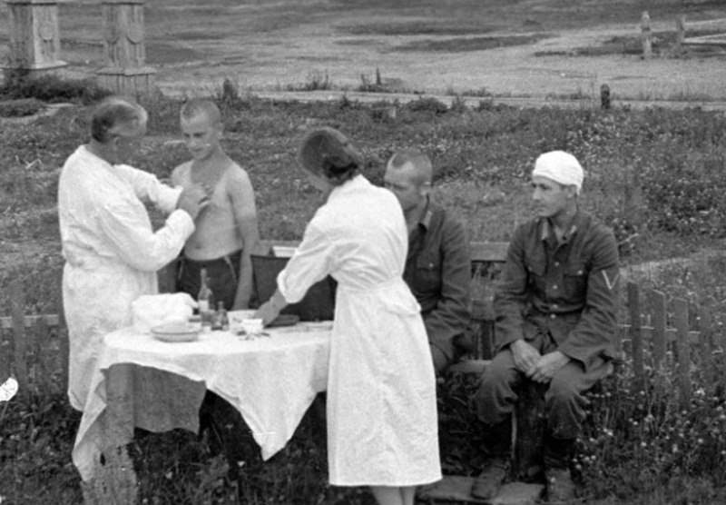 Немецкие солдаты во время приема на медпункте спецгоспиталя.