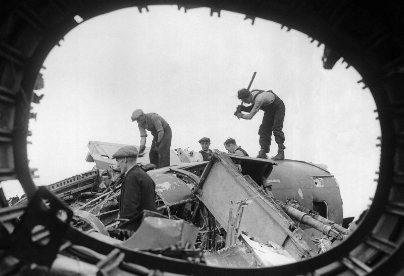 Английские рабочие разбирают на переплавку остатки сбитых немецких бомбардировщиков. Август 1940 г. 