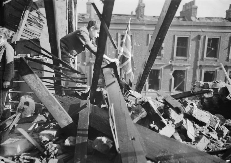 Мальчик устанавливает британский флаг на развалинах своего дома в Лондоне. 1940 г. 